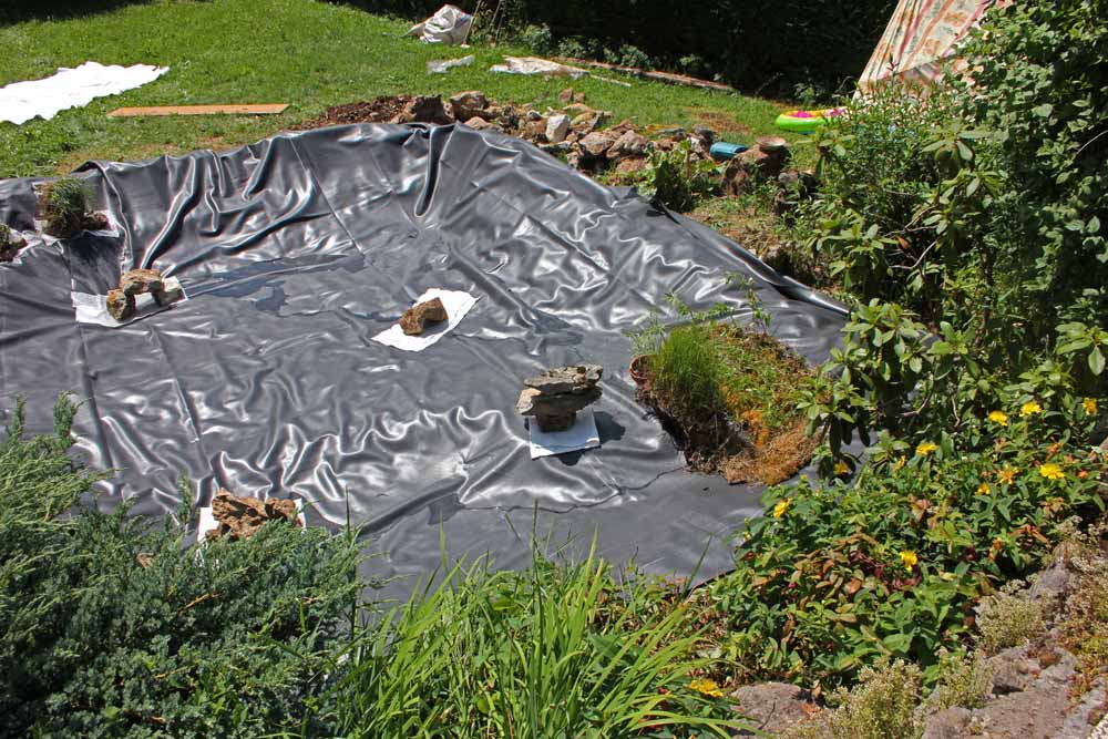 Mise en place de la bâche EPDM et des caches à poissons au fond de la mare